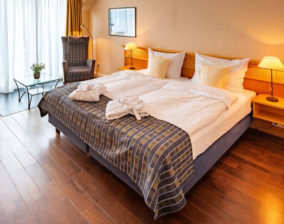 Ein gemachtes Doppelt in einem Schlafzimmer in einer Ferienwohnung in Norddorf auf Amrum.