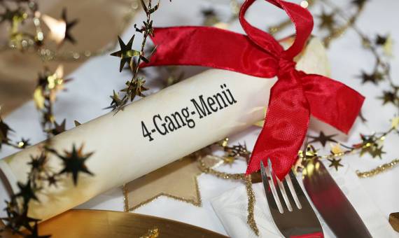 Ein weihnachtlich dekorierter Tisch mit Menürolle für ein festliches 4-Gang-Menü im Hotel Hüttmann